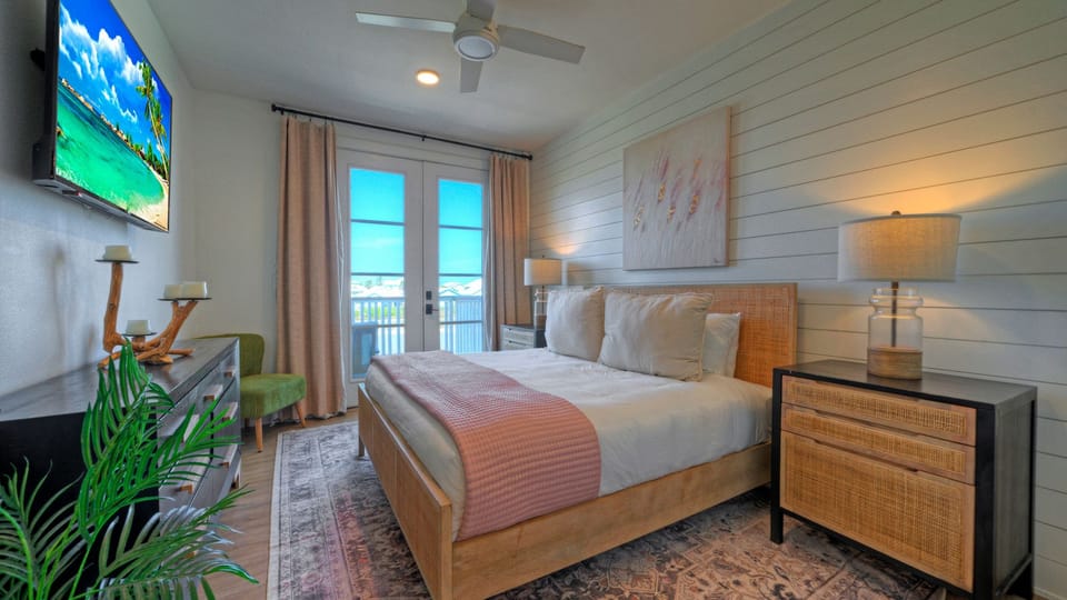 The primary bedroom features a king bed, TV, balcony and an ensuite bathroom.