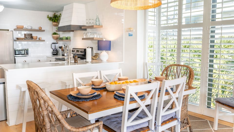 Coastal‑bright kitchen and dining space with natural textures, fresh light, and a relaxed seaside feel.