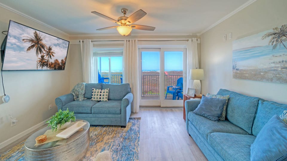 Bright, coastal living space with a comfortable sofa and TV.