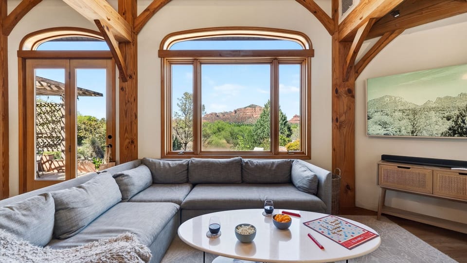 Relax in a light-filled living space framed by soaring beams and stunning red rock views just beyond the window.