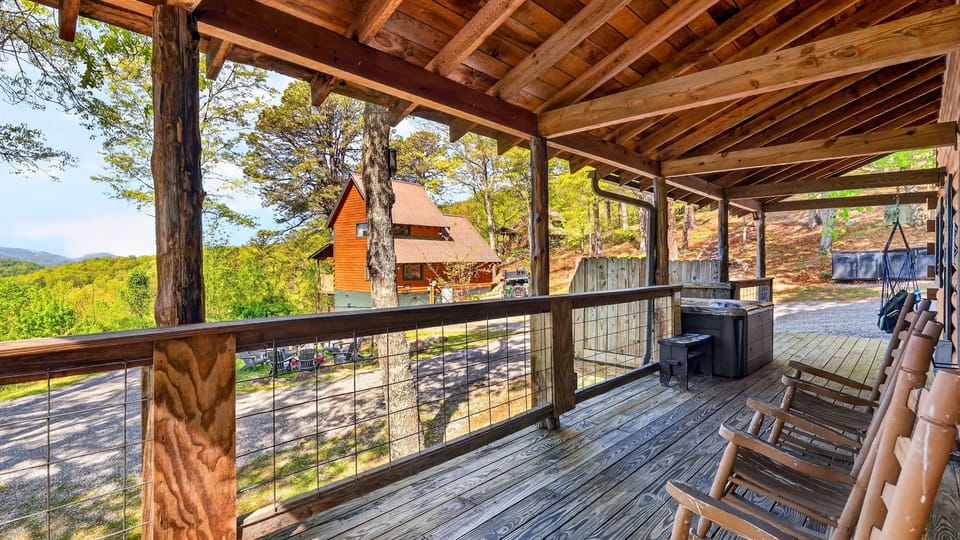 A classic wraparound porch with rocking chairs and a private hot tub—perfect for slow mornings and sunset unwinding in the mountains.