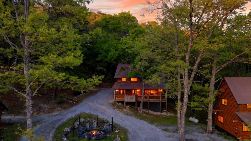 A cozy cabin retreat nestled in the trees, complete with a fire pit gathering area—perfect for unforgettable Smoky Mountain evenings.