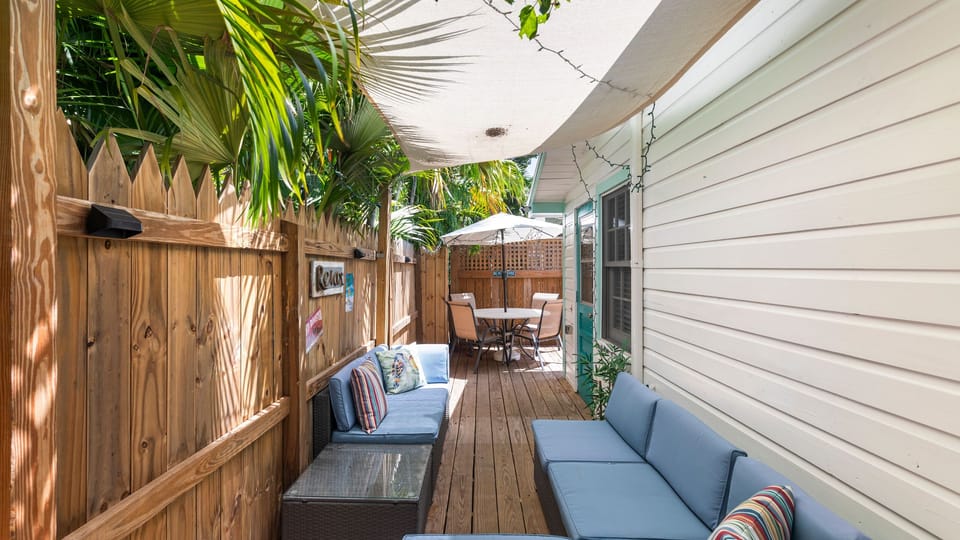 Comfortable outdoor lounge area with wicker seating and shaded deck.