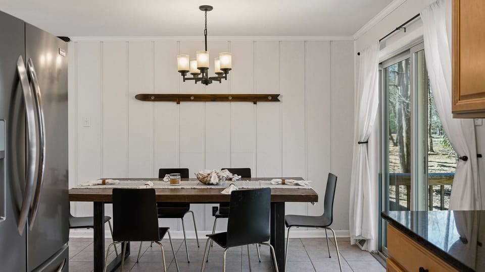 Sleek dining area with seating for six and a view of the forest.