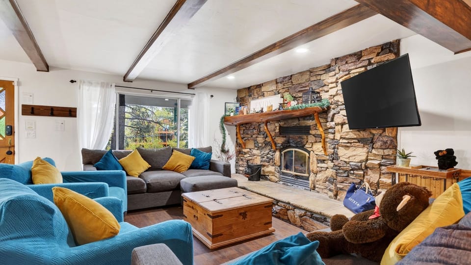 Inviting living room with stone fireplace, plush seating, and cozy cabin charm.