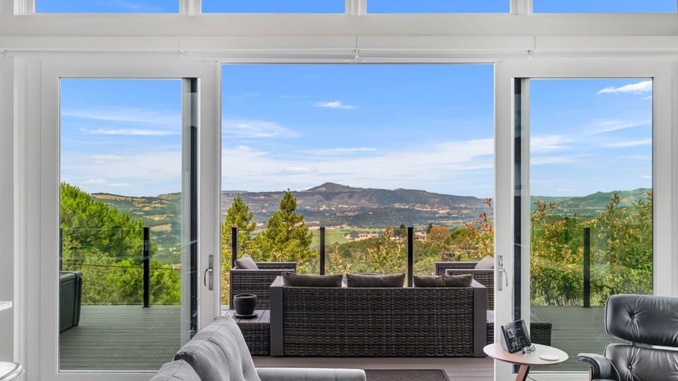 Panoramic mountain views visible through the massive sliding glass doors.