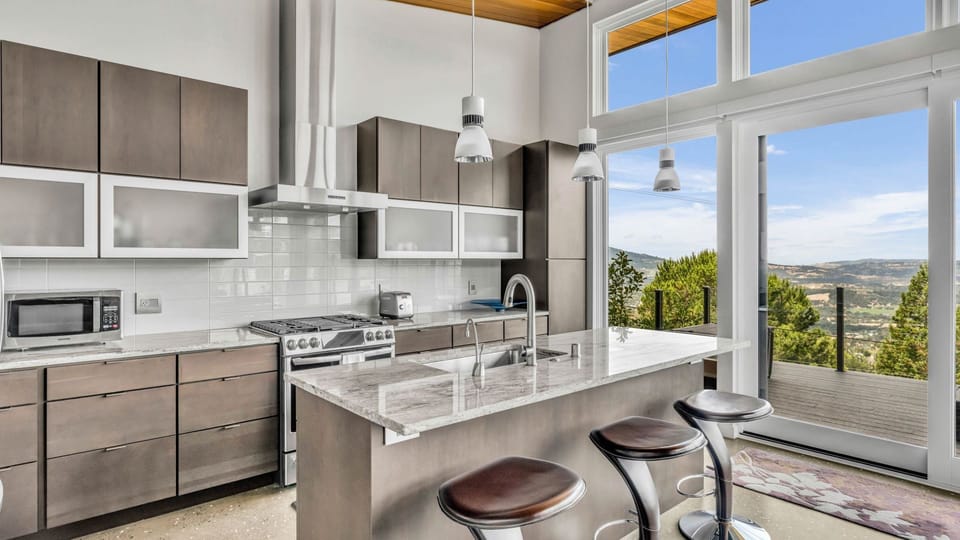 Modern gourmet kitchen with high-end stainless steel appliances and an island breakfast bar.