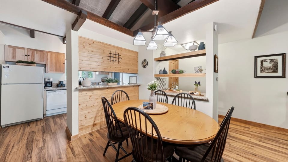 Warm, open dining area with vaulted wood-beam ceilings and easy kitchen access.