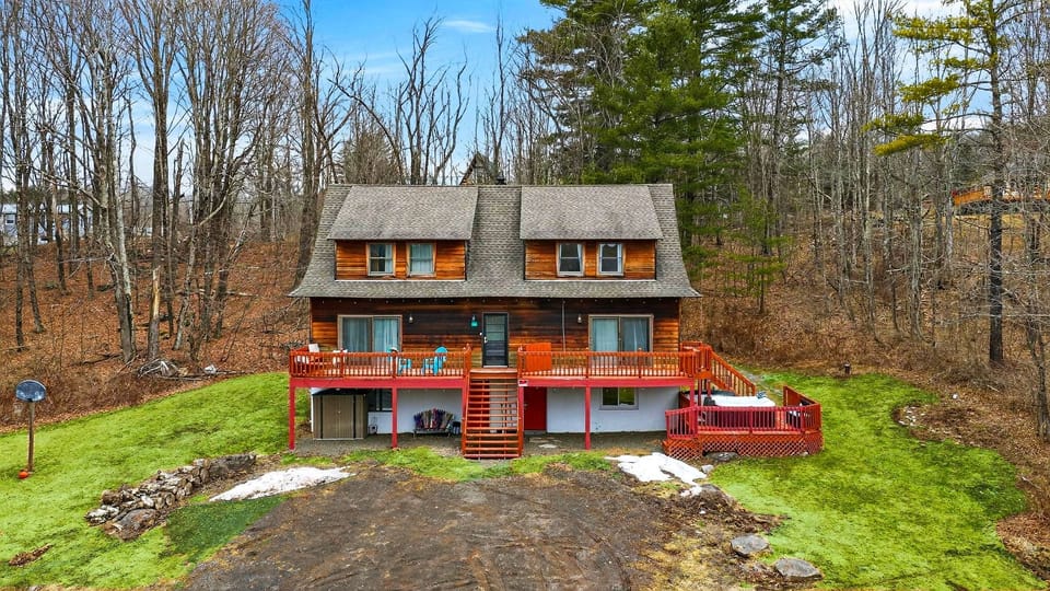 A classic cabin-style escape with a large deck, hot tub, and room to unwind in a peaceful wooded setting.