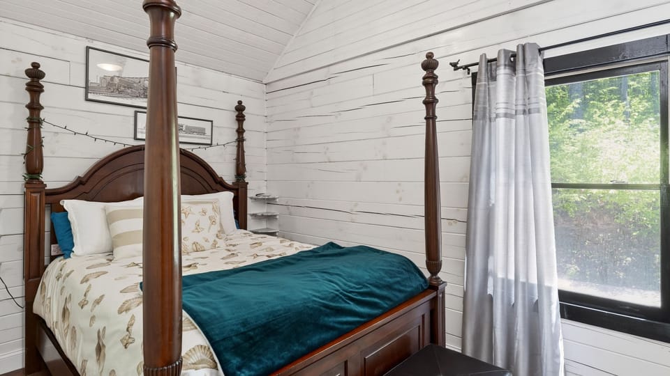 Drift off to sleep in this stunning four-poster bed set against classic white shiplap.