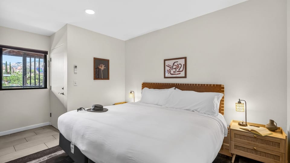 Unwind in a serene king bedroom designed with warm accents, plush bedding, and a calming modern aesthetic.