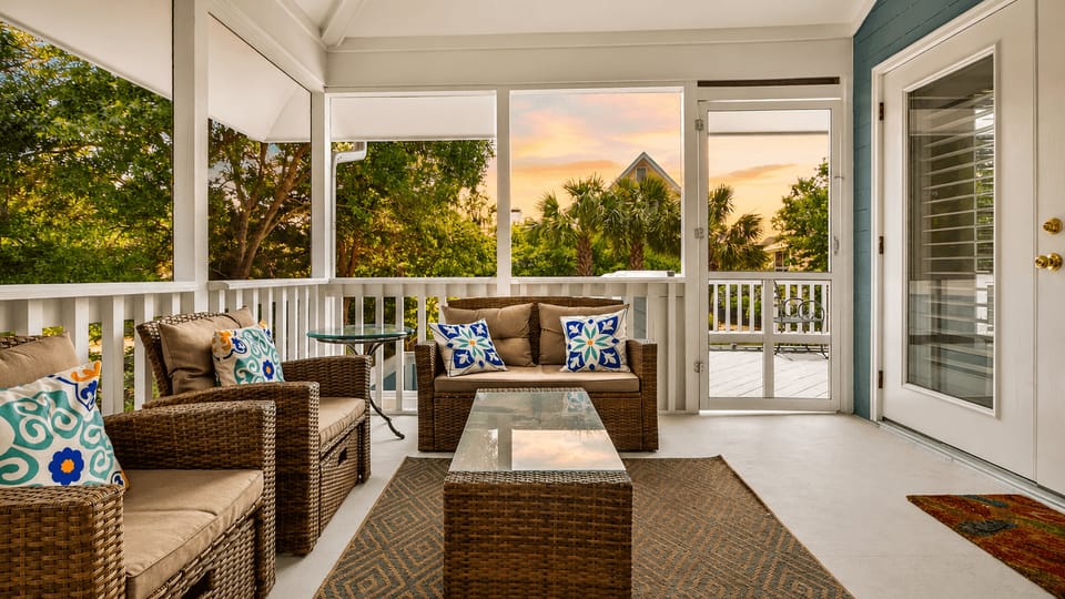 Unwind on the screened-in porch with cozy seating and breezy views of the surrounding palms.