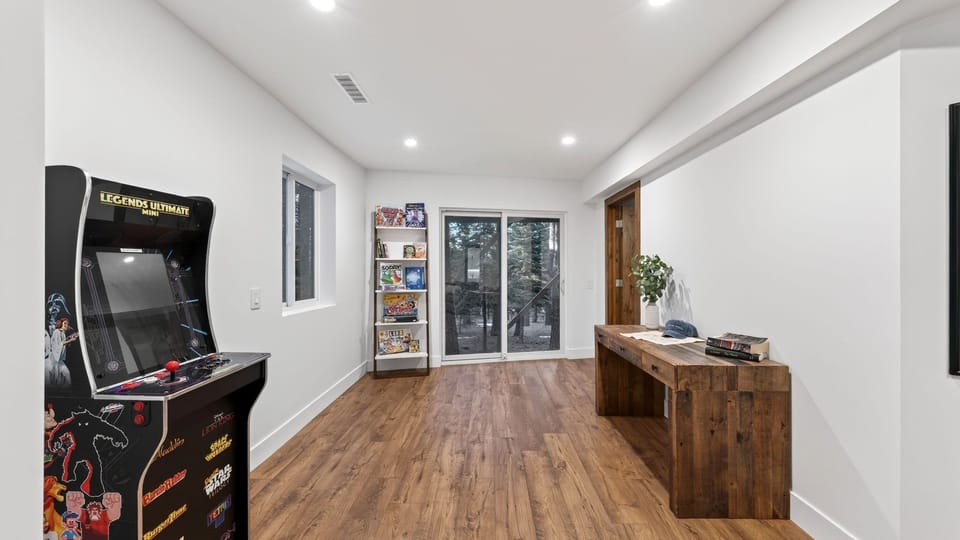 Secondary lounge area with arcade and board games. Flexible space that can serve as a movie room or additional space.