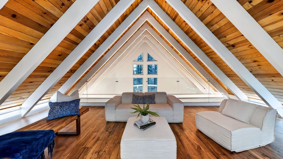 A cozy loft overlook featuring a queen sleeper sofa area nestled under the A-frame.