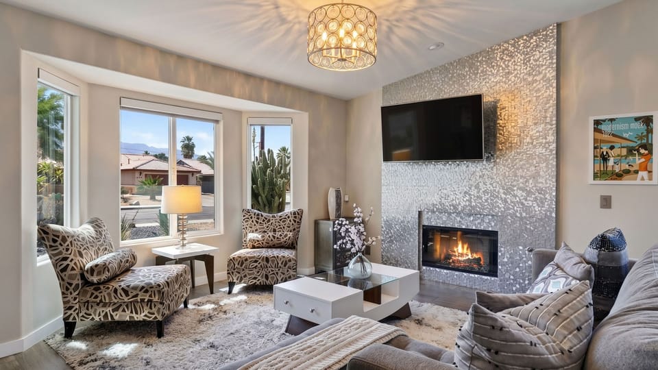 Bright, sophisticated living room showcasing high-end contemporary furnishings, a chic textured accent fireplace wall, and a wall-mounted TV.