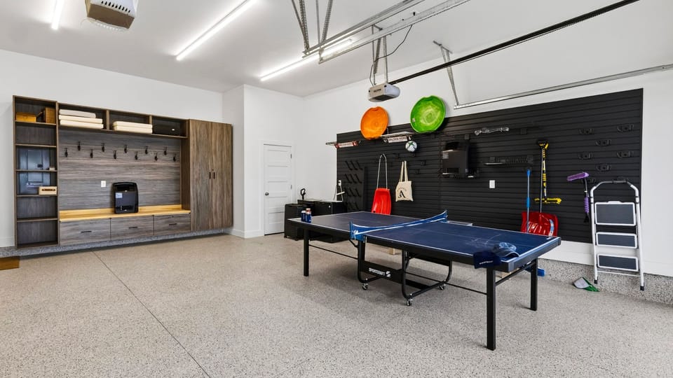 Spacious garage game zone with ping pong, gear storage, and room for group fun.