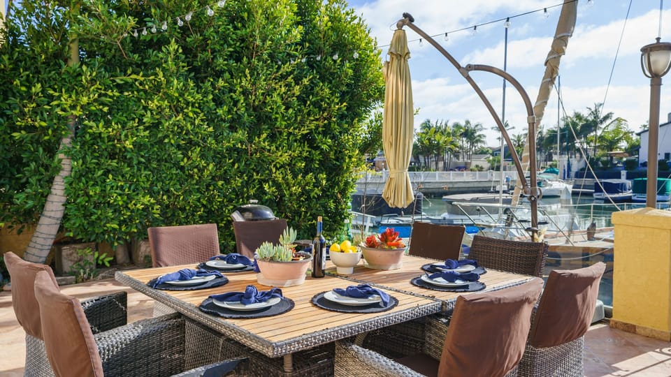 Waterfront patio dining with marina views, string lights, and plenty of space to gather outdoors.
