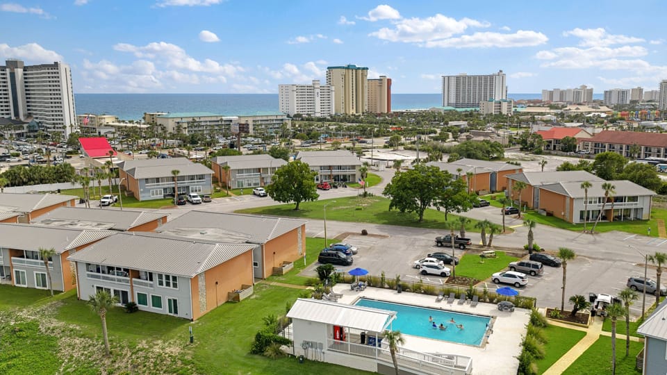 High-angle drone shot capturing the community layout with the beautiful oceanfront high-rises just a short distance away.