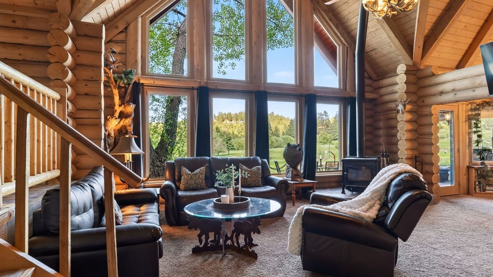 Great room with soaring windows, log cabin charm, and peaceful mountain views.
