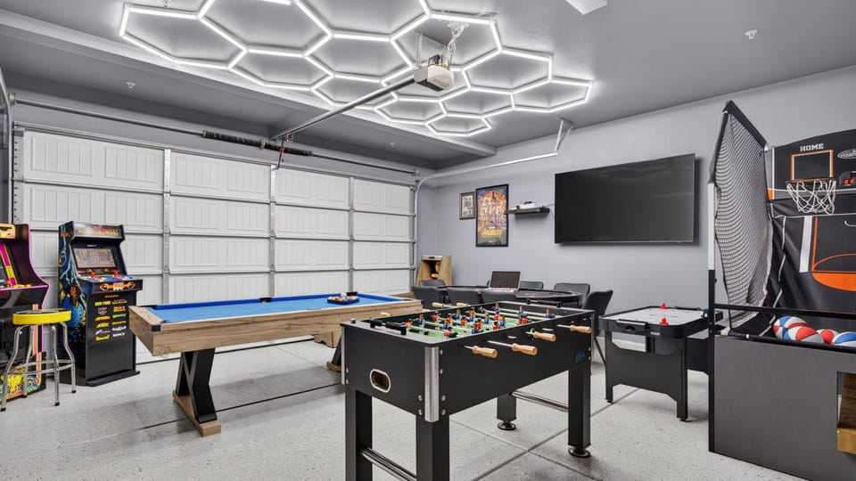 The ultimate garage transformation—a fully loaded game room illuminated by ultra-modern hexagonal LED ceiling grids.