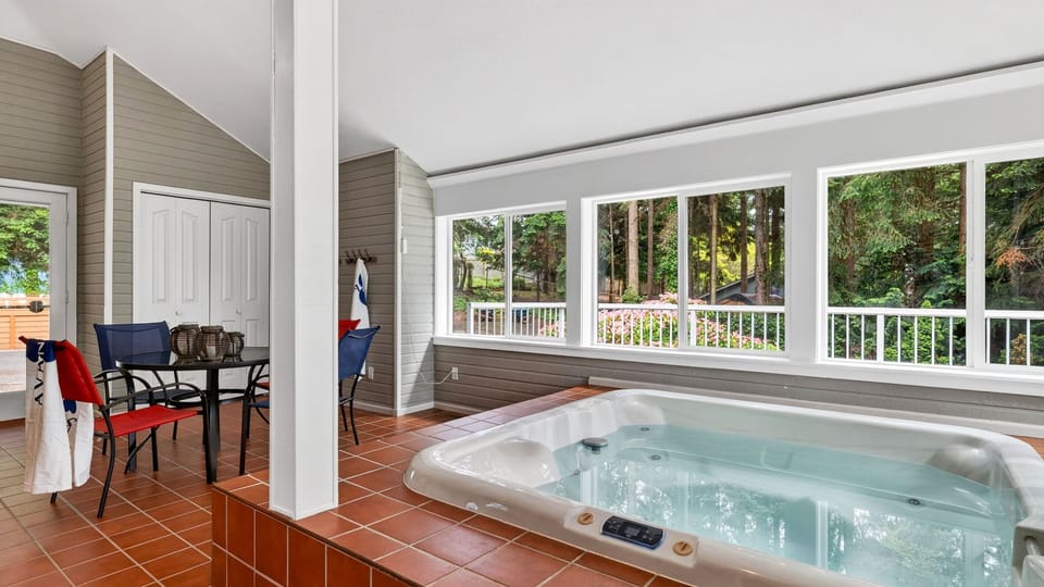 Soak in the indoor hot tub while enjoying peaceful wooded views through oversized windows.