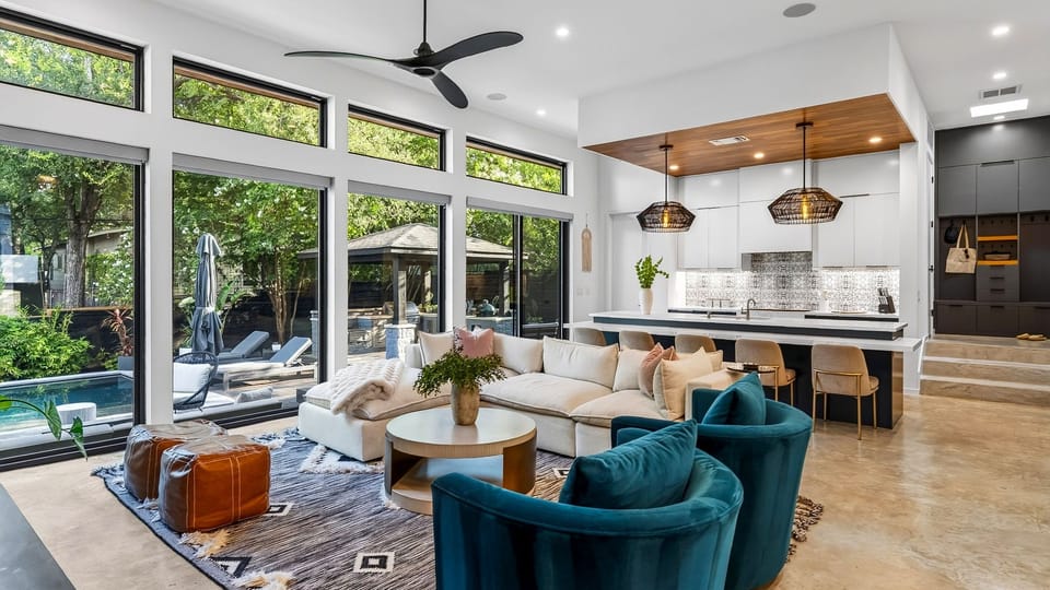 The open-concept great room pairs plush seating and a sleek kitchen with seamless access to the poolside patio.