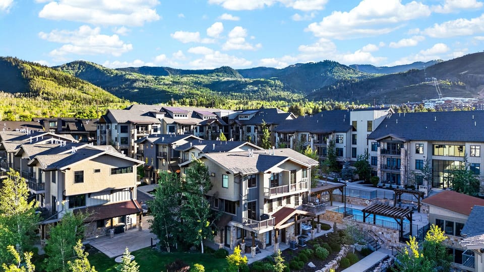 High-angle daytime perspective illustrating the expansive mountain valley and bright blue skies.