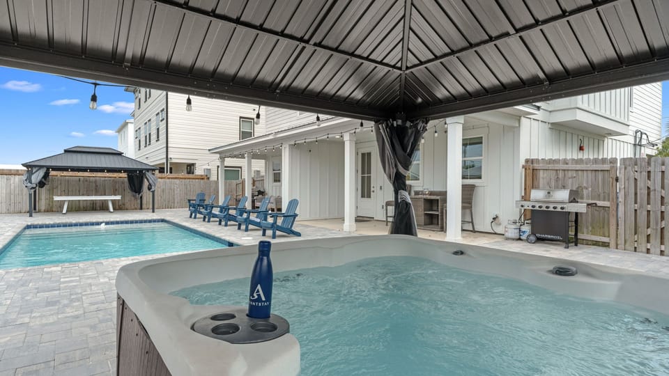 Covered hot tub overlooking the private pool and lounge seating area.