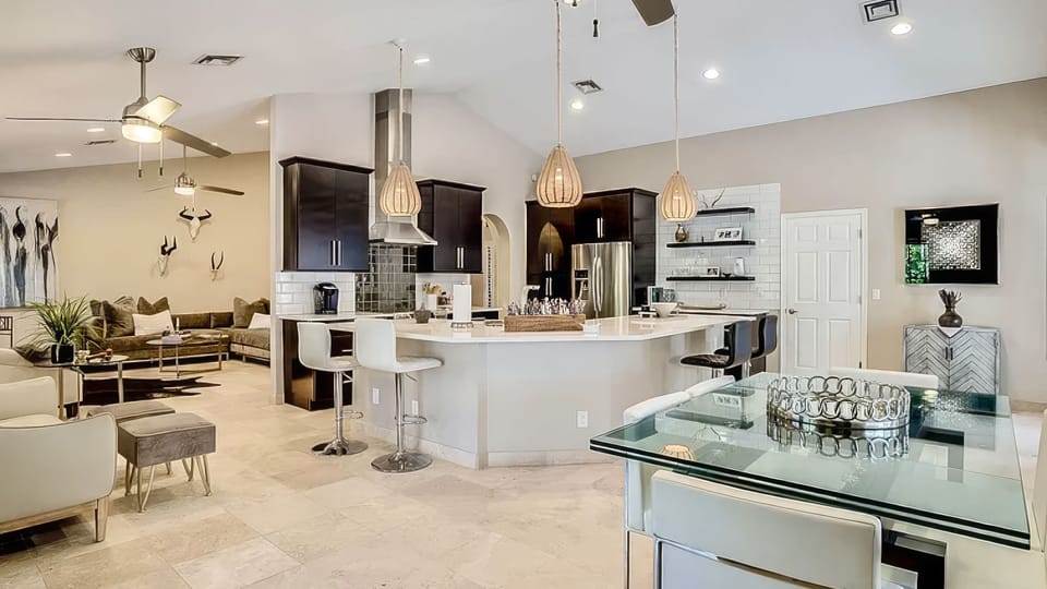 Open-concept living, dining, and kitchen area with bar seating, modern finishes, and a bright airy feel.