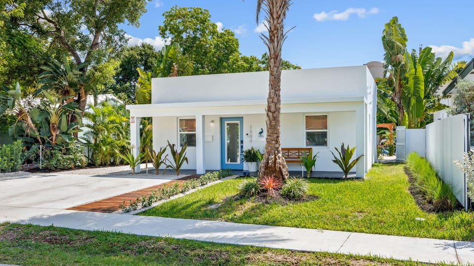 Modern single-story home with private driveway and lush landscaping.