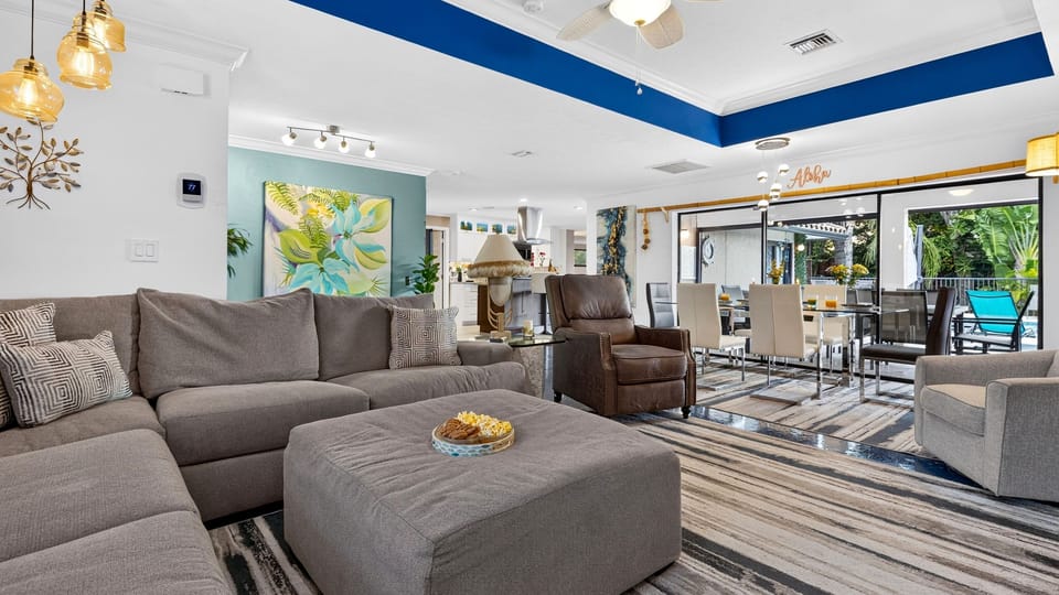 Spacious open-concept living and dining area with tropical style and direct poolside views.