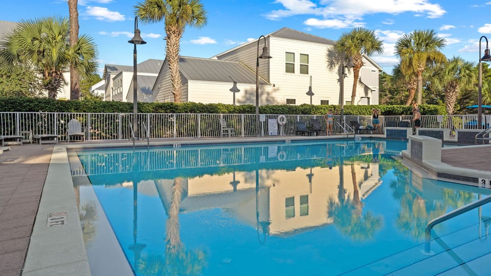 Cool off at the community pool, surrounded by palm trees, lounge seating, and a relaxed coastal setting.