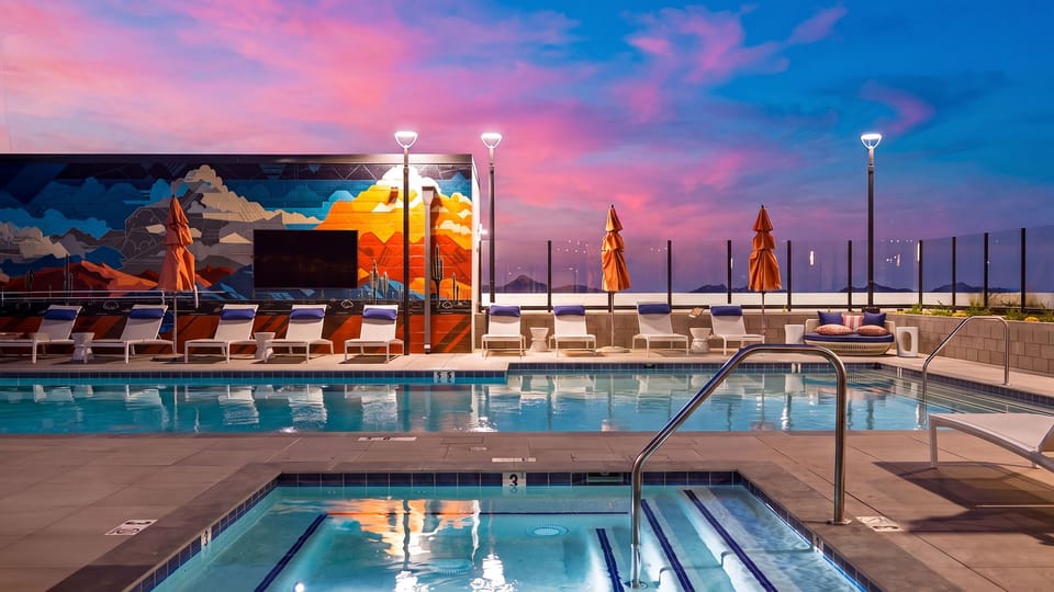 Take a refreshing swim in the rooftop community pool, framed by colorful murals and sweeping mountain views.