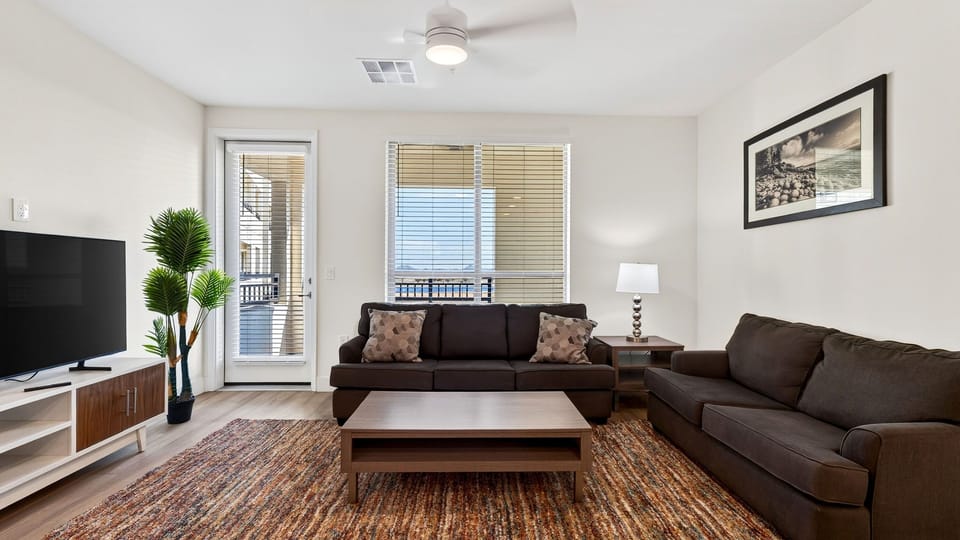 Bright, open living room with comfortable seating and balcony access.
