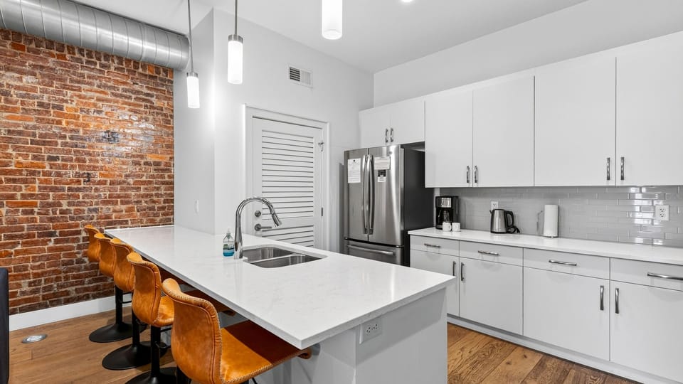 Cook and gather in the sleek kitchen, featuring a spacious island with seating for five.