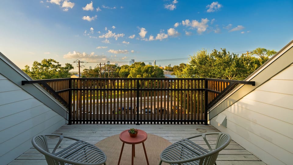 Private upper deck with lounge seating, skyline glimpses, and golden-hour neighborhood views.