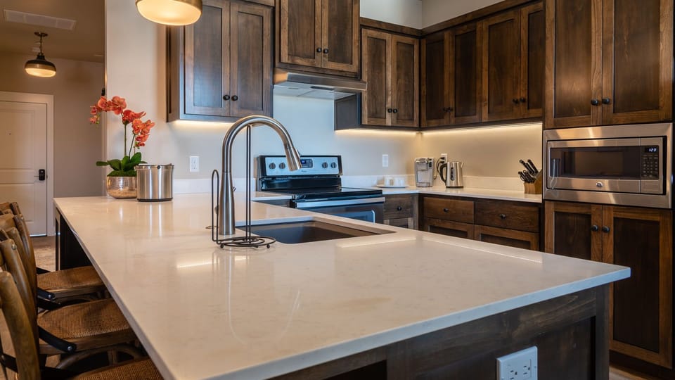 The quartz-topped island offers prep space and casual seating in this kitchen.