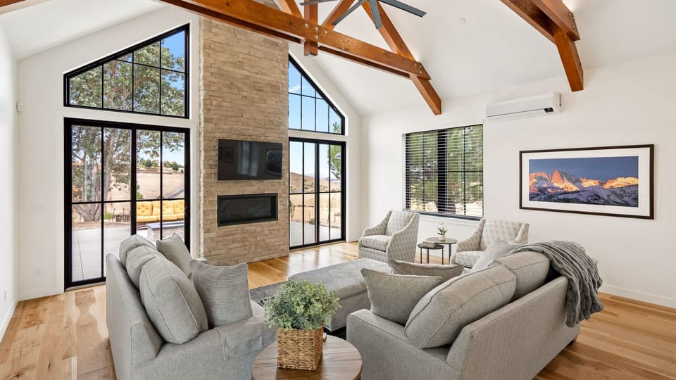 Gather by the fireplace beneath vaulted wood beams
