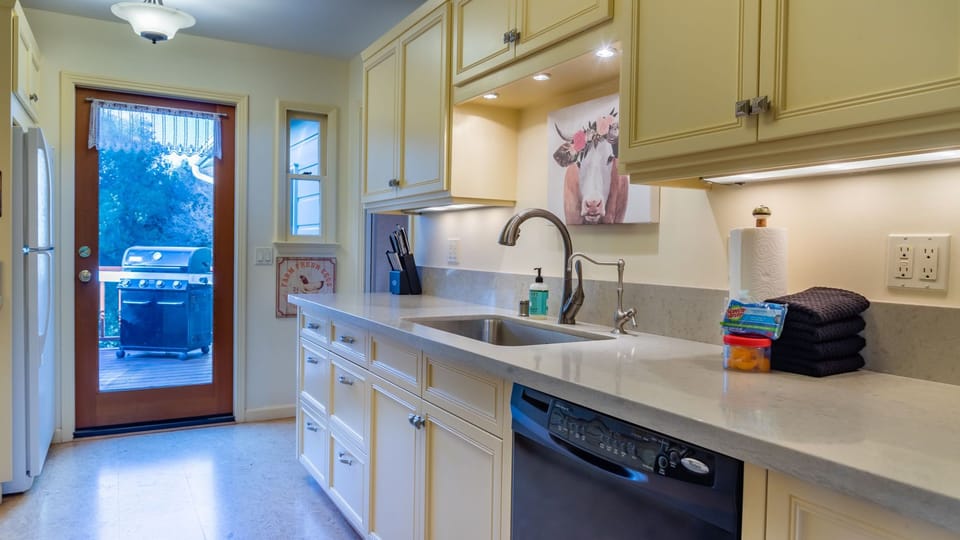 The bright kitchen makes group meals easy with generous counters, ample cabinetry, and deck access.