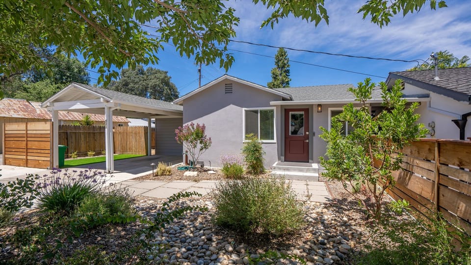 A paved path beside the carport leads to the covered front door