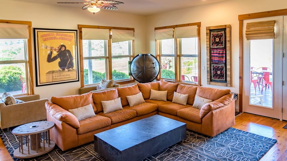 Sunlit lounge with plush seating, warm wood details, and inviting windows.