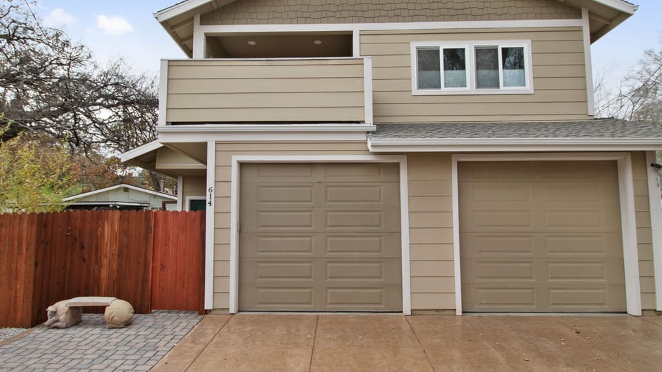Covered balcony and dual garage frame the front entry