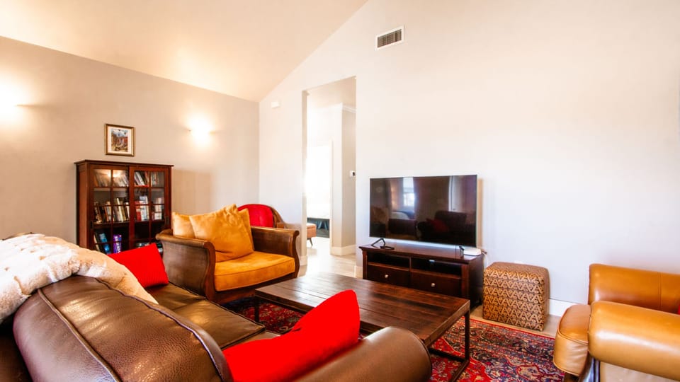 Kick back in the living room with a TV, soft seating, and a comfortable book-filled corner.
