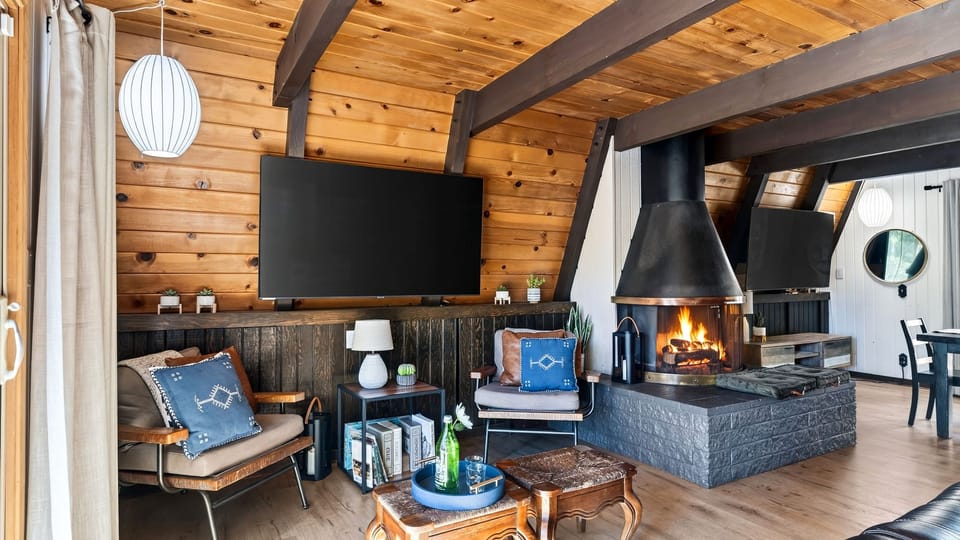 Cozy living area featuring wood-paneled walls, leather seating, and a fireplace.