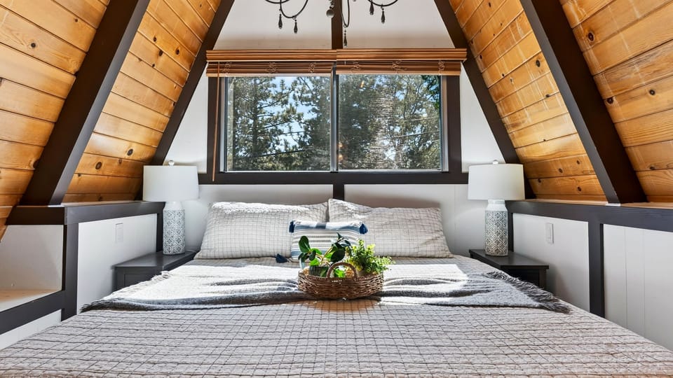 Primary bedroom with an A-frame ceiling and a queen bed.