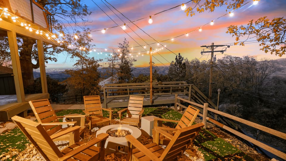 Outdoor deck patio string lights and firepit overlooking a scenic mountain view.