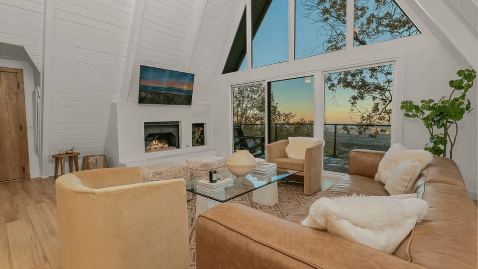 Vaulted living room with floor-to-ceiling windows and plush seating.