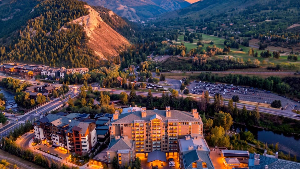 A sunset aerial captures the resort’s prime mountain setting, surrounded by sweeping valley views and alpine scenery.