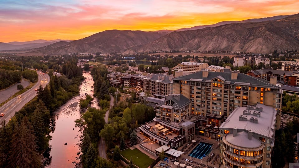 A sunset aerial showcases the resort’s riverfront setting, framed by sweeping mountain and valley views.