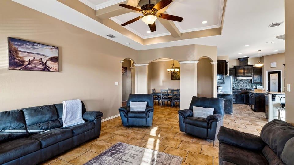 A spacious living room offers plenty of seating with easy flow into the dining area and kitchen.